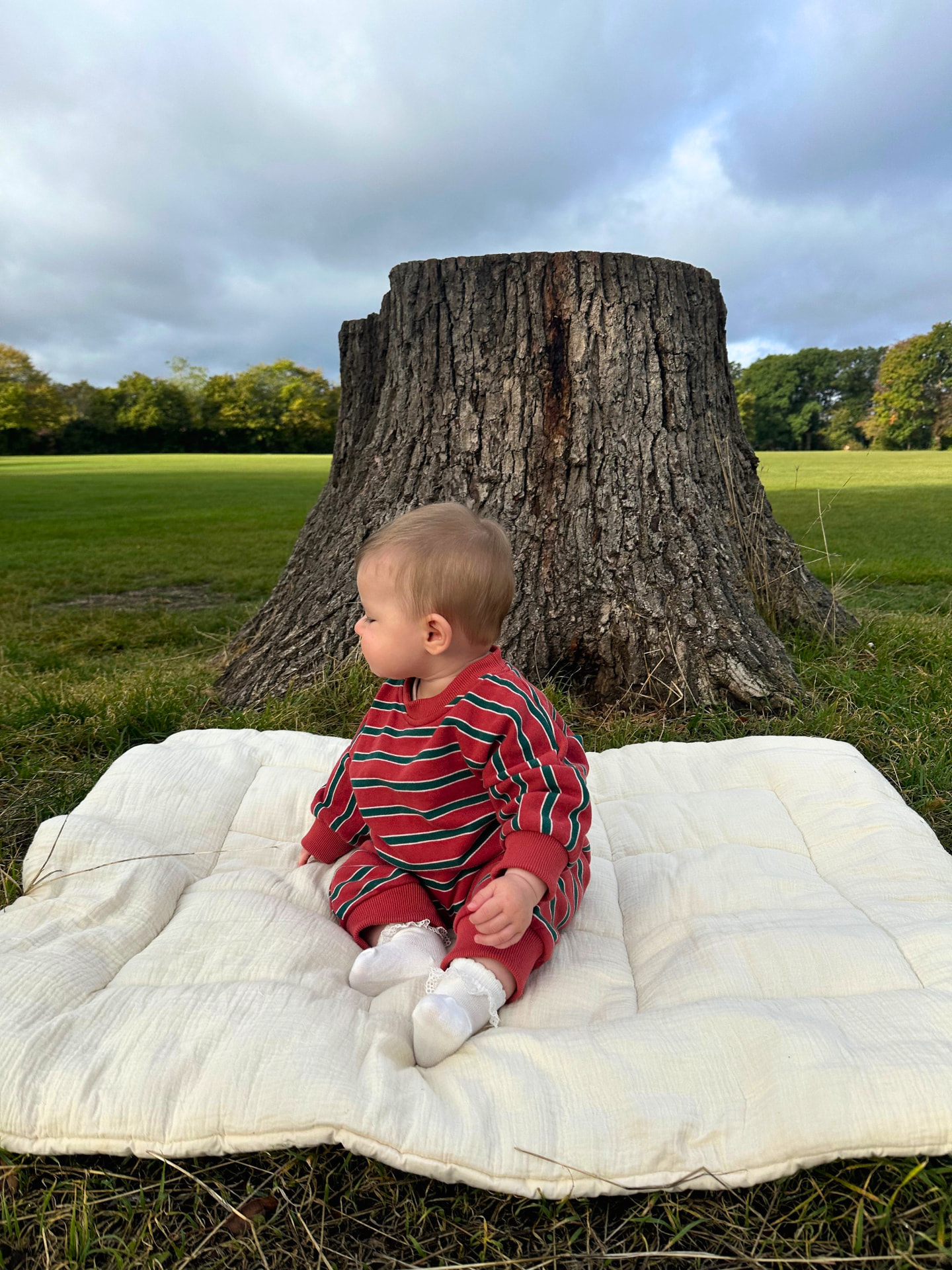 Baby wearing the Heritage Red striped oversized cozy bodysuit outdoors